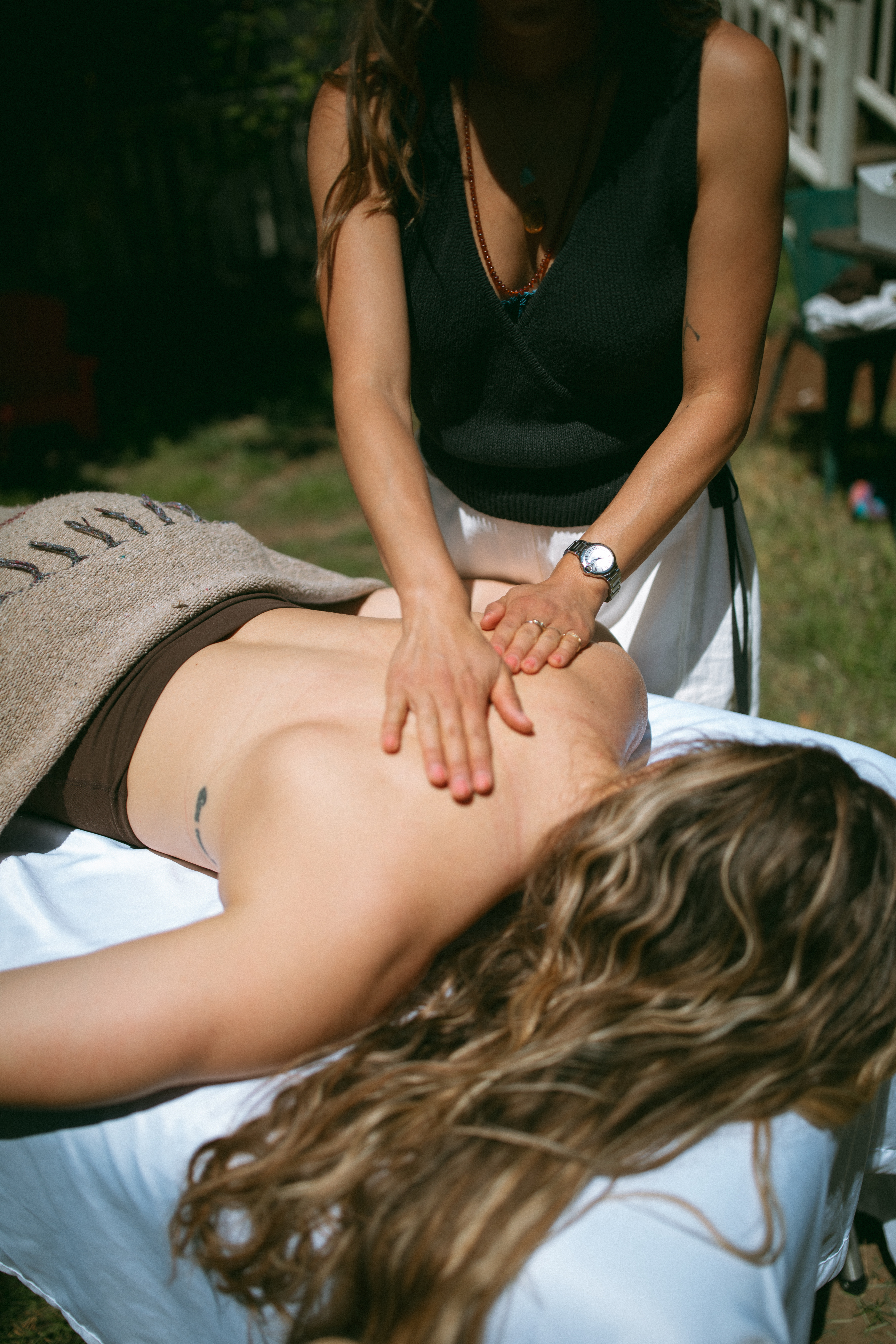 Dr. Sarah Swanson providing bodywork during an outdoor in-home care visit.